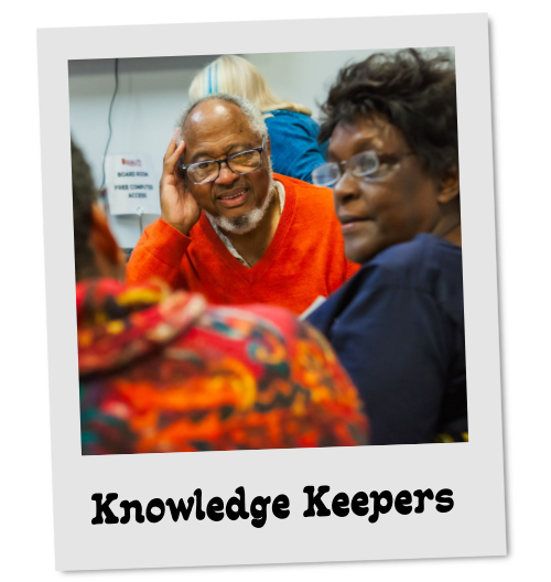 Photo styled as a tilted polaroid labeled "Knowledge Keepers." Black elders sit close together in conversation.